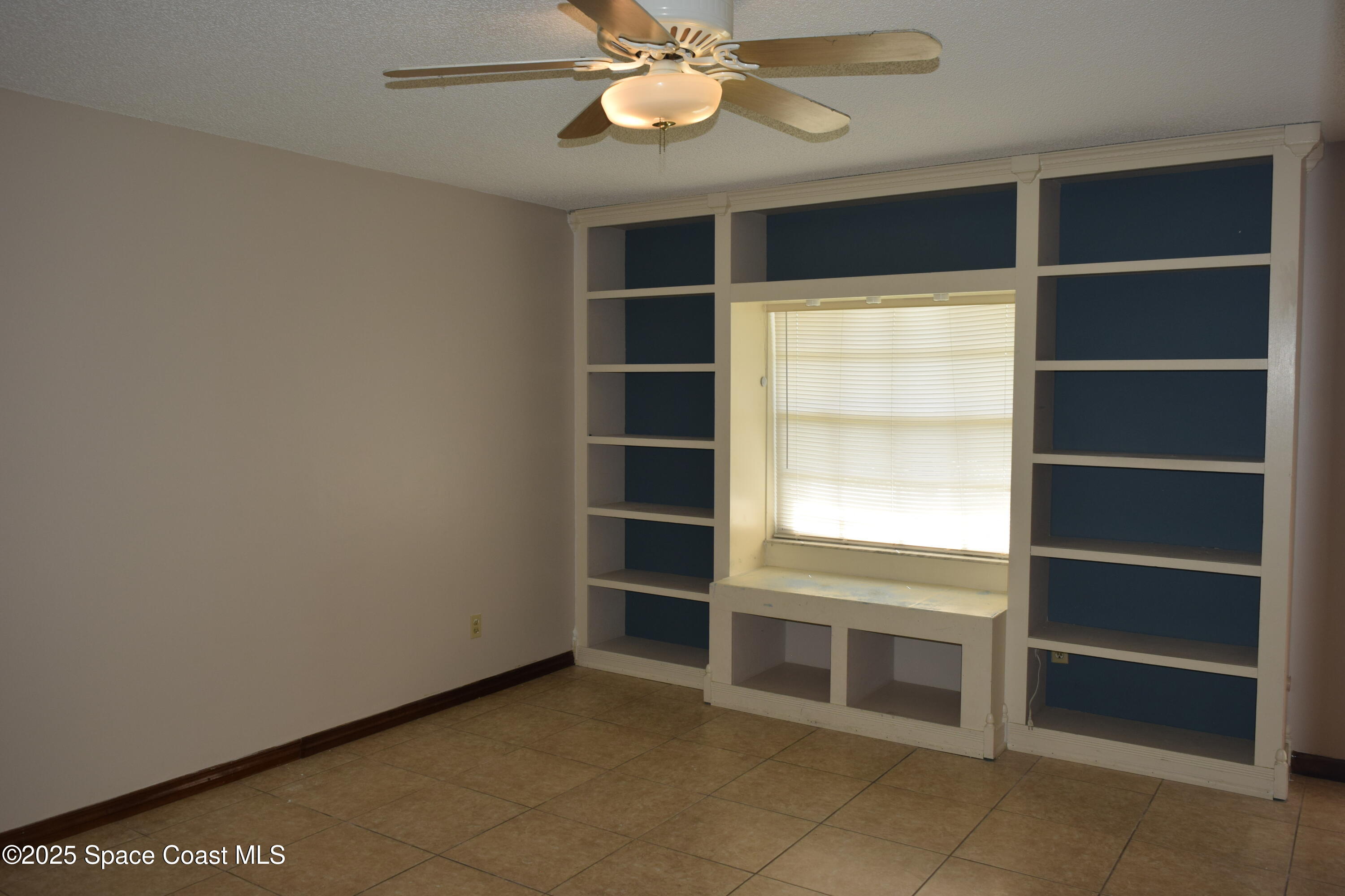 1941 Talloak Road Melbourne, FL 32935 - Photo 22 of 34 a view of an empty room with a window and a kitchen