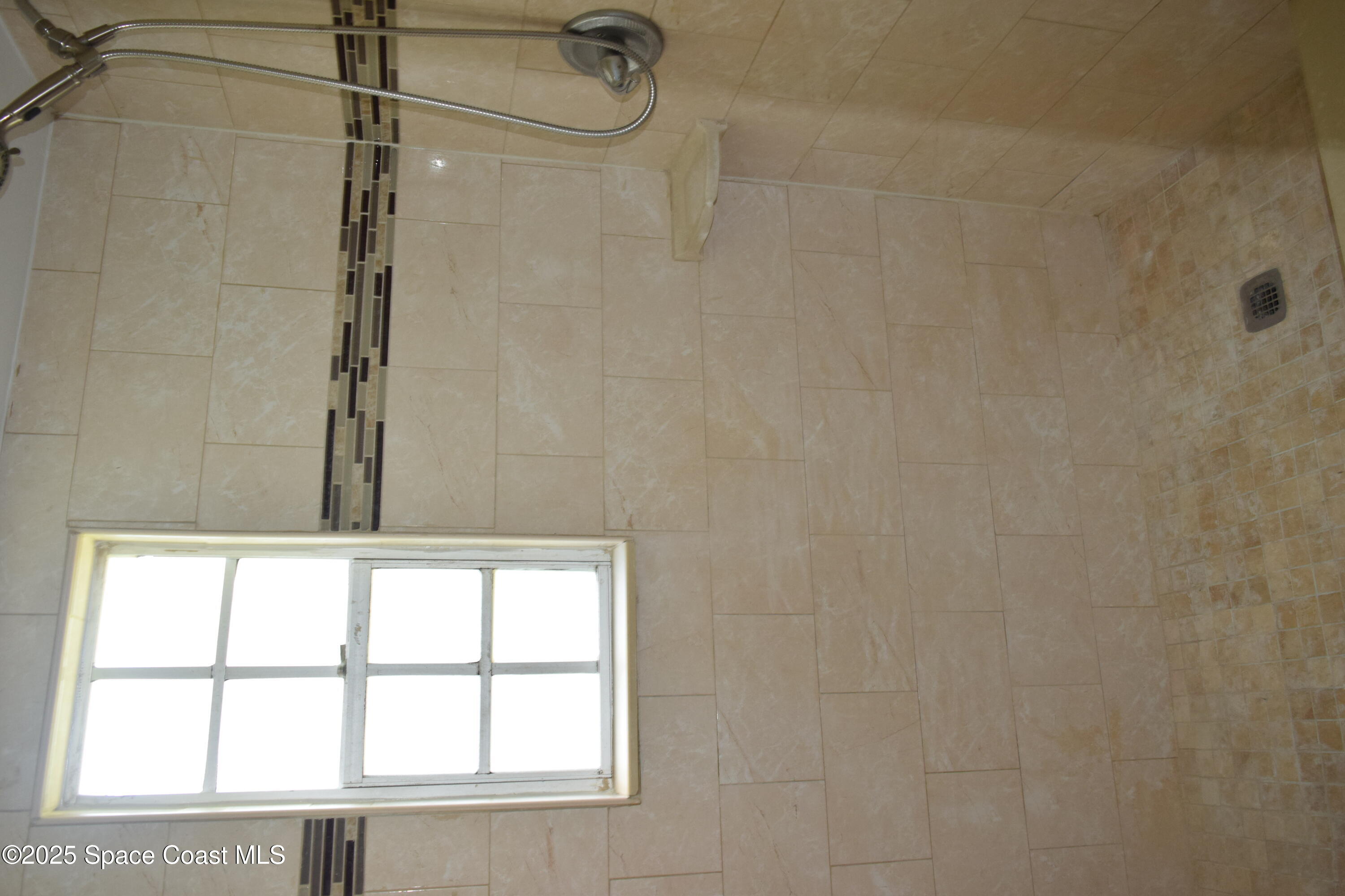 1941 Talloak Road Melbourne, FL 32935 - Photo 30 of 34 a bathroom with a window and a shower