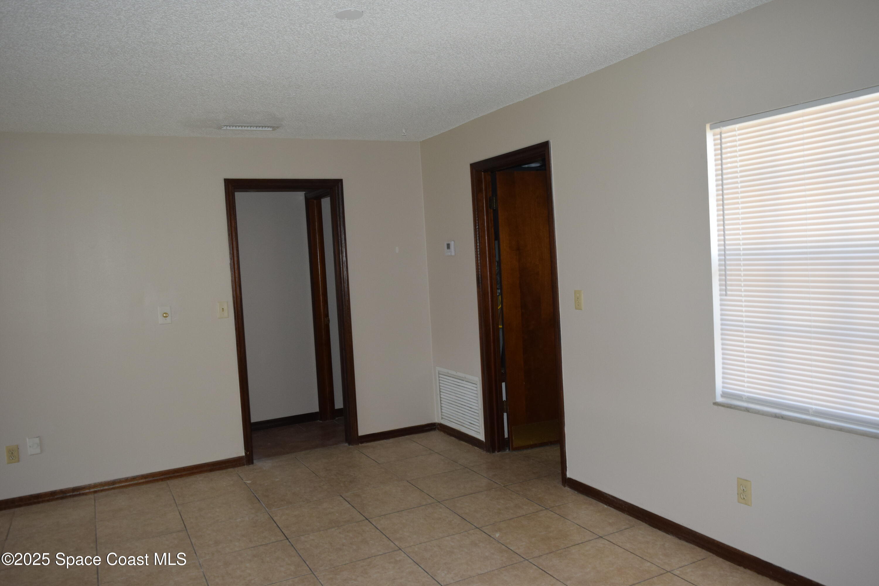 1941 Talloak Road Melbourne, FL 32935 - Photo 7 of 34 a view of an empty room with a window