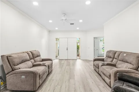 an empty room with windows and ceiling fan
