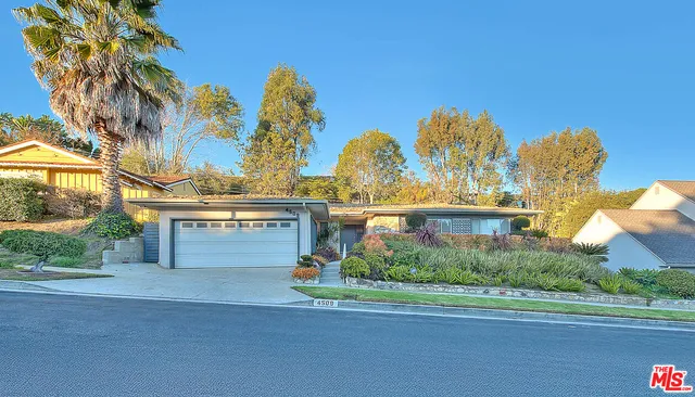 a view of a house with a yard and potted plants