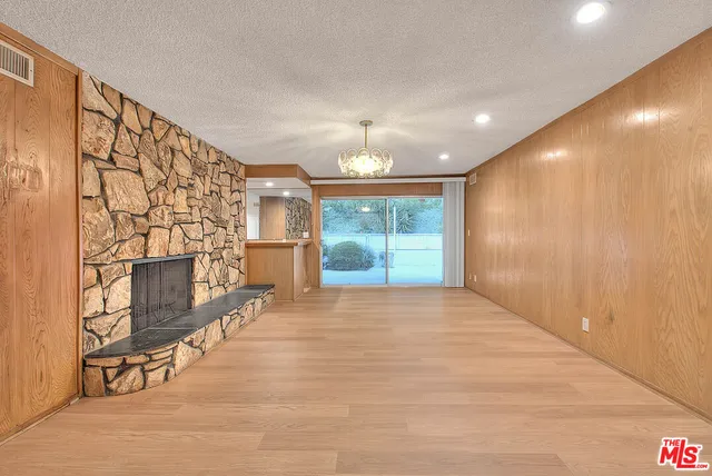 a view of an empty room with a birdcage and a window