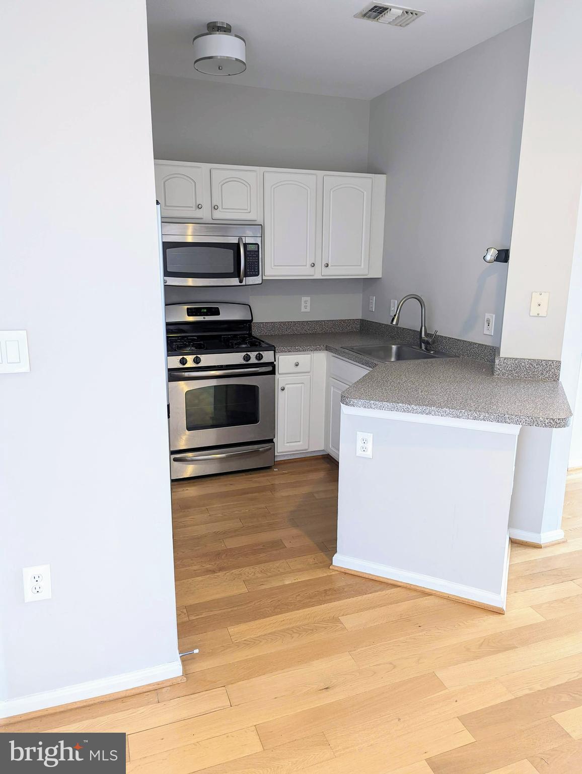 21765 Ascot Court Ashburn, VA 20147 - Photo 8 of 32 a kitchen with stainless steel appliances granite countertop a sink stove and white cabinets