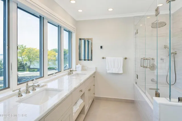 a bathroom with a granite countertop sink mirror and a bathtub