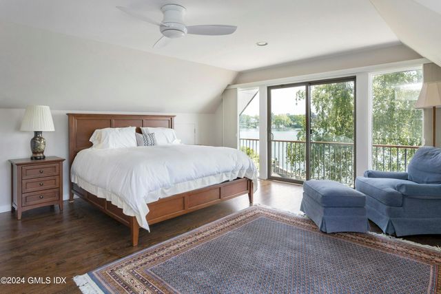 a bedroom with a bed couch and a large window