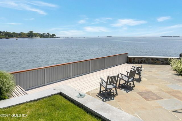 a view of swimming pool with seating area and lake view