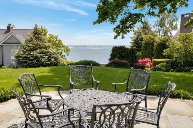 a view of a chairs and table in patio with a yard