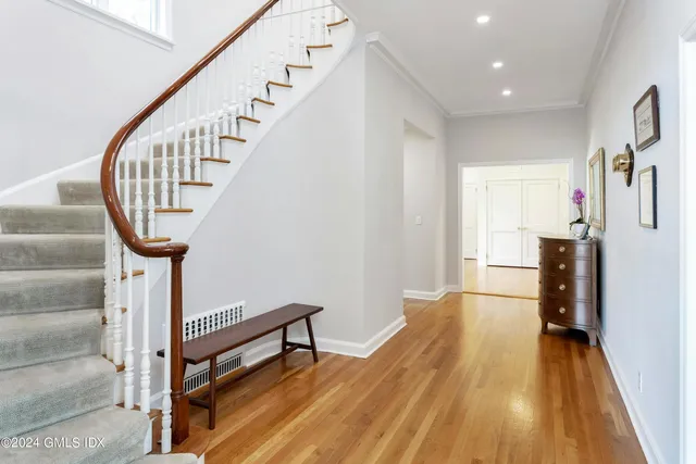 a view of a hallway with wooden floor and staircase