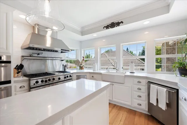 a kitchen with stainless steel appliances a stove a sink and a refrigerator