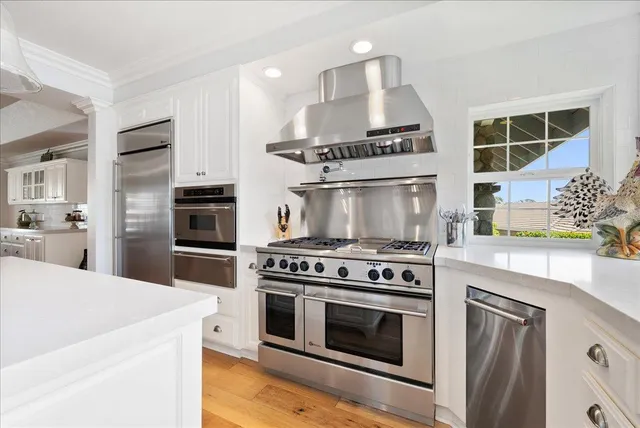 a kitchen with white cabinets and stainless steel appliances