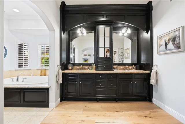 a bathroom with a bathtub a mirror a sink and a shower