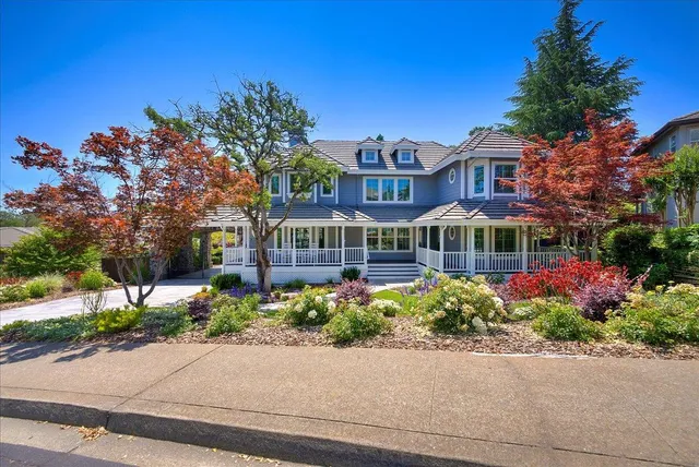 a front view of a house with a yard and potted plants