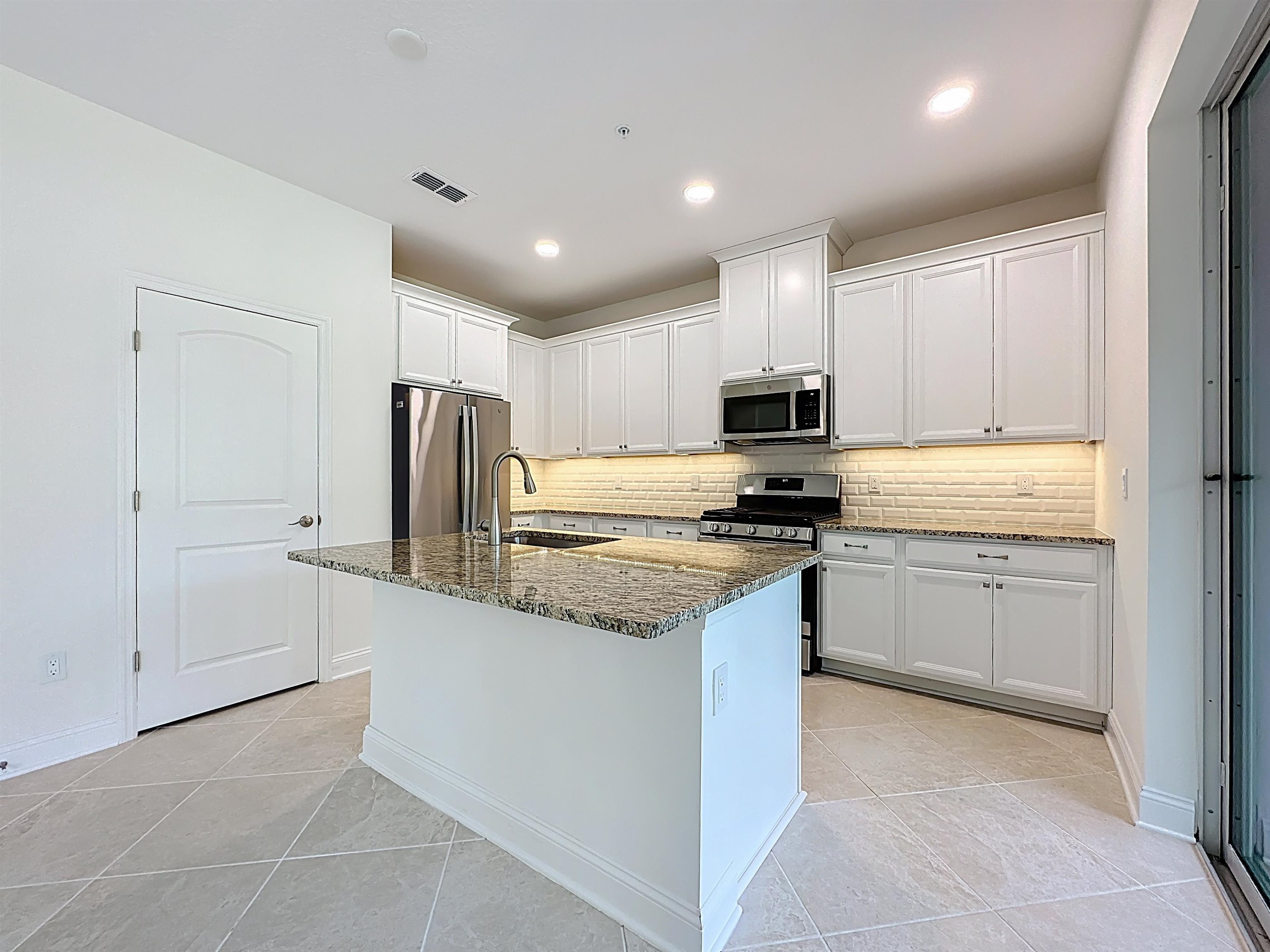 251 Grand Ravine Drive St. Augustine, FL 32086 - Photo 15 of 37 a kitchen with stainless steel appliances granite countertop a refrigerator and a stove top oven