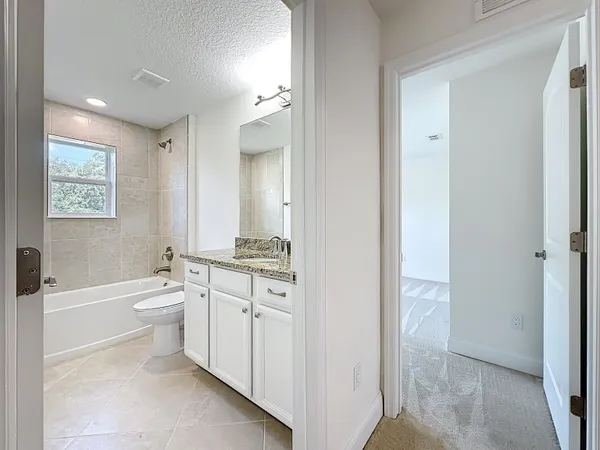 a bathroom with a tub shower and toilet