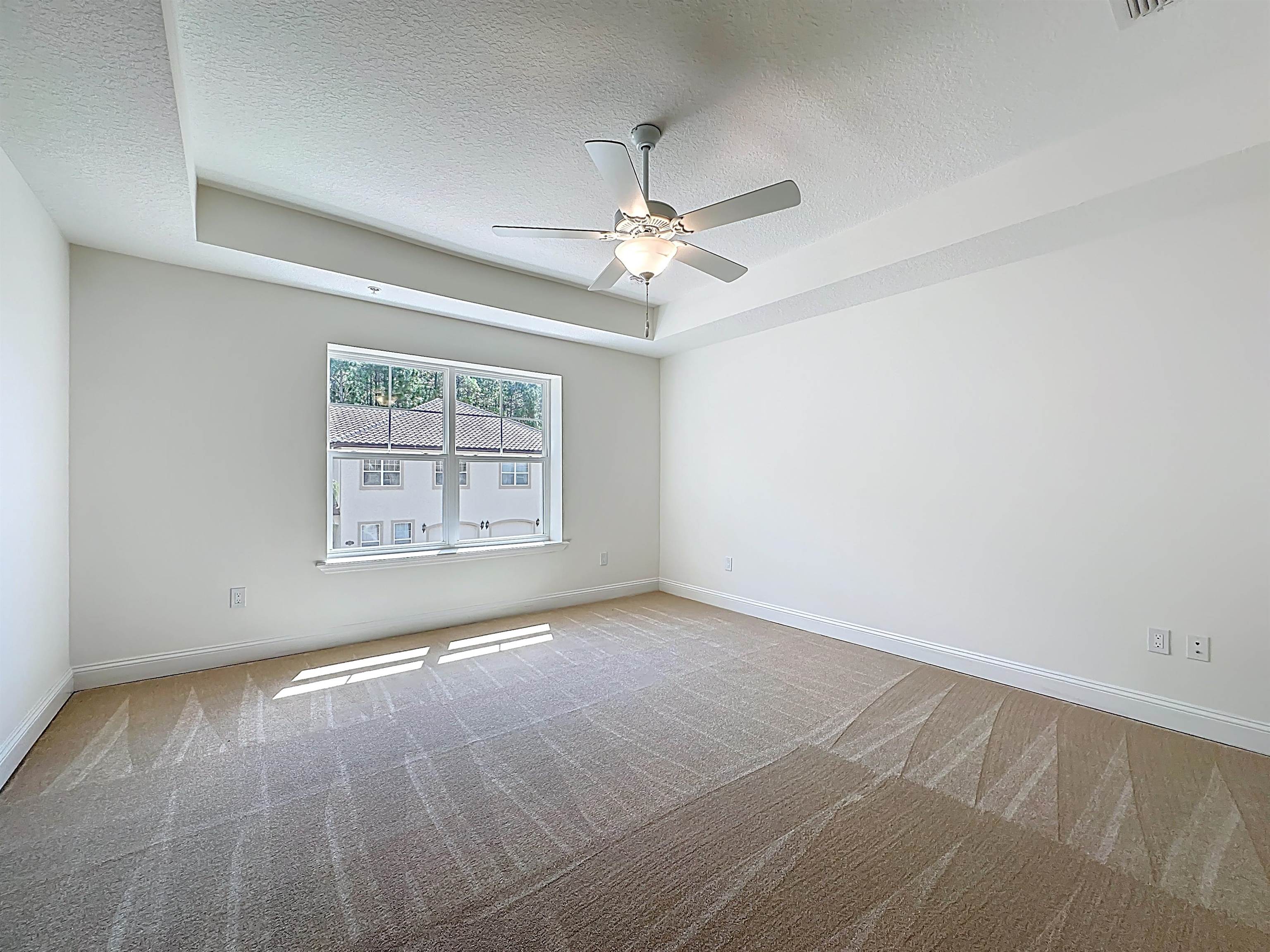 251 Grand Ravine Drive St. Augustine, FL 32086 - Photo 29 of 37 an empty room with wooden floor chandelier fan and windows