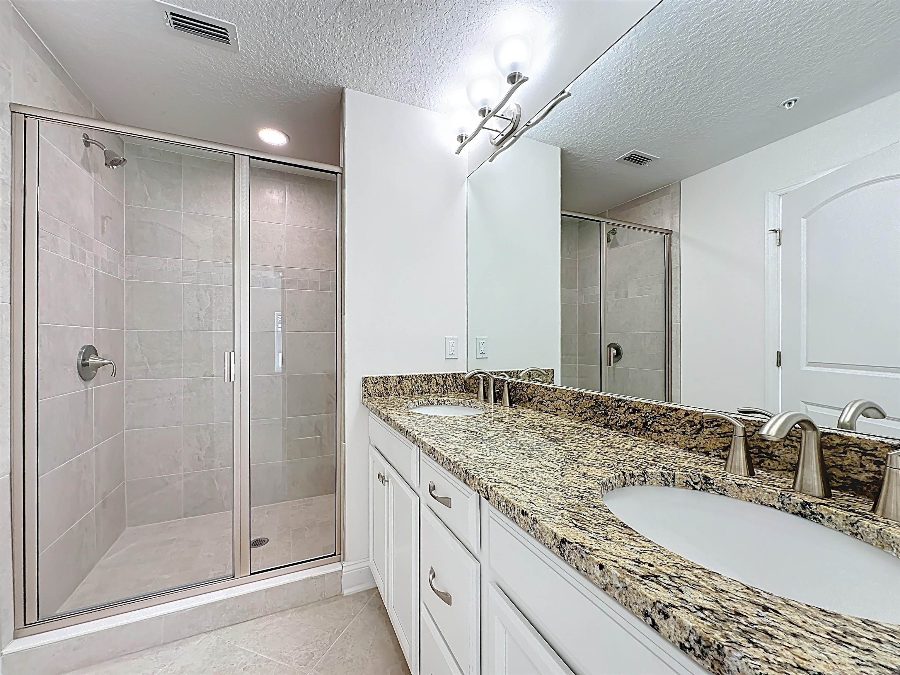 251 Grand Ravine Drive St. Augustine, FL 32086 - Photo 32 of 37 a bathroom with a granite countertop sink shower and a mirror