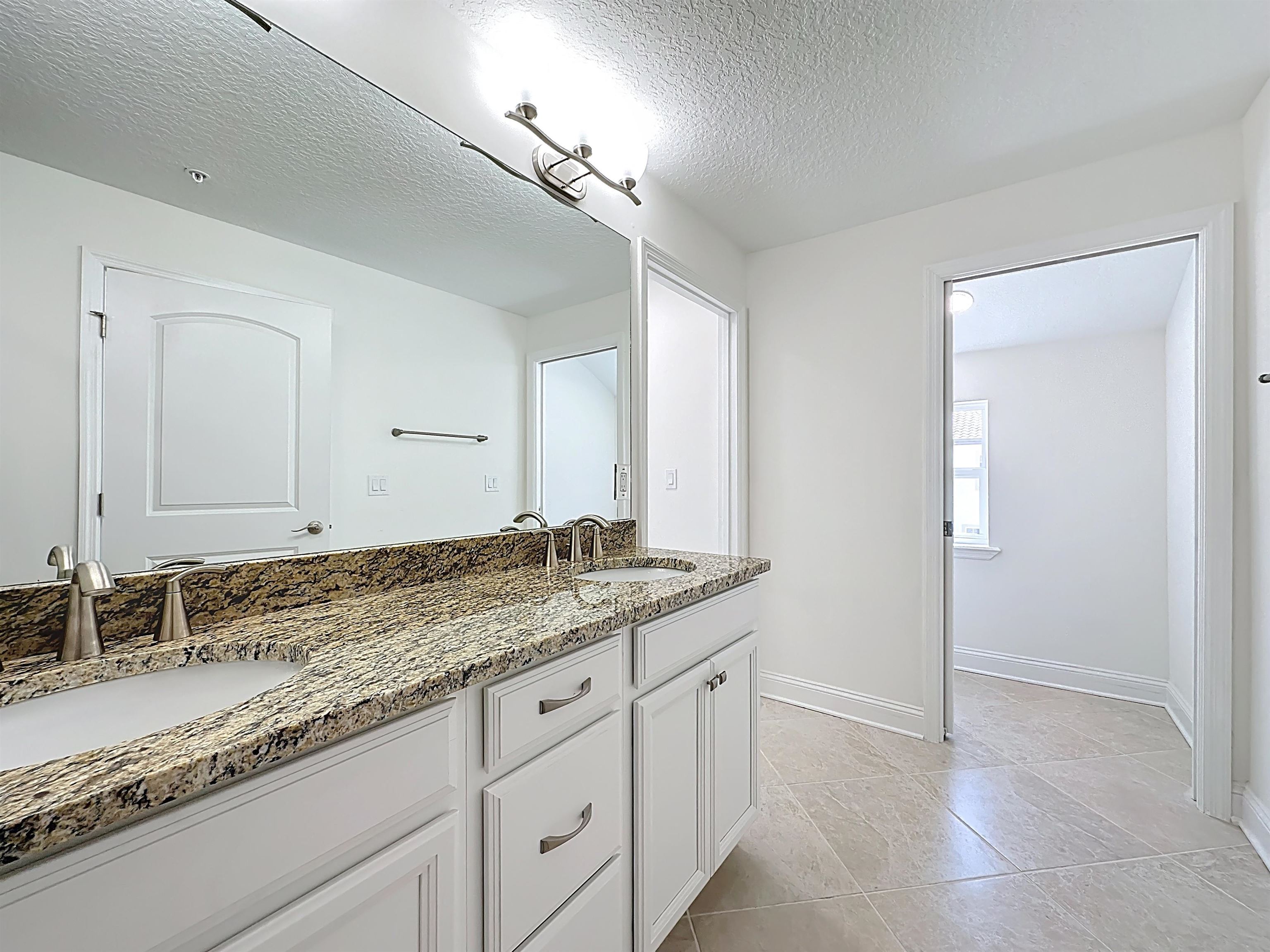 251 Grand Ravine Drive St. Augustine, FL 32086 - Photo 33 of 37 a bathroom with a granite countertop sink and a mirror