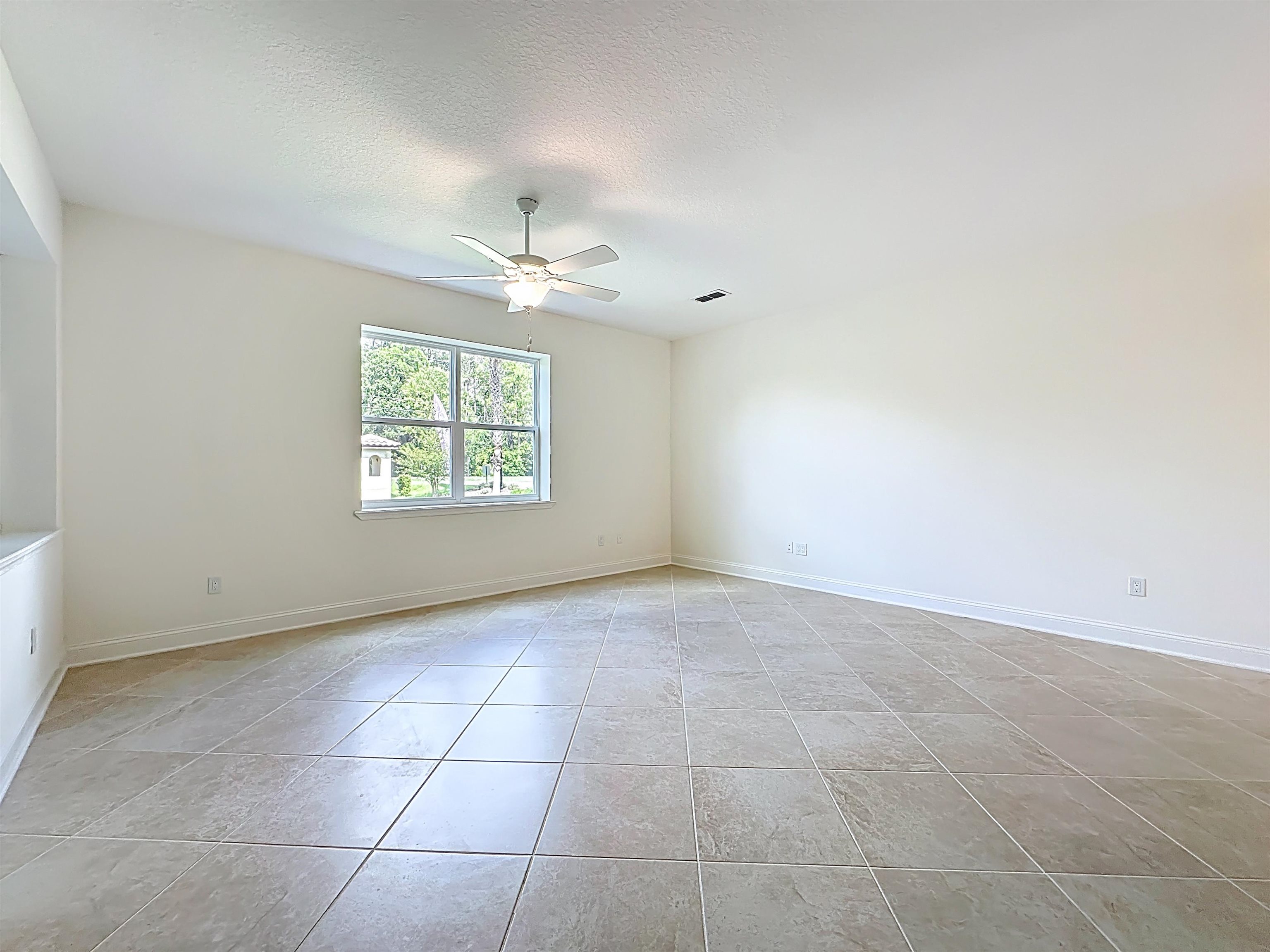 251 Grand Ravine Drive St. Augustine, FL 32086 - Photo 10 of 37 an empty room with windows and chandelier fan