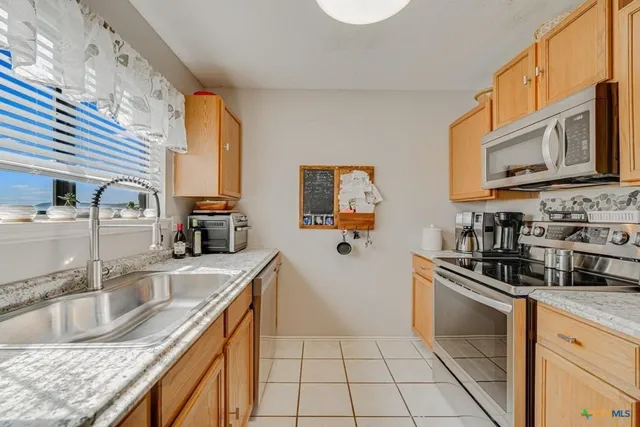 a kitchen with stainless steel appliances granite countertop a sink stove and cabinets