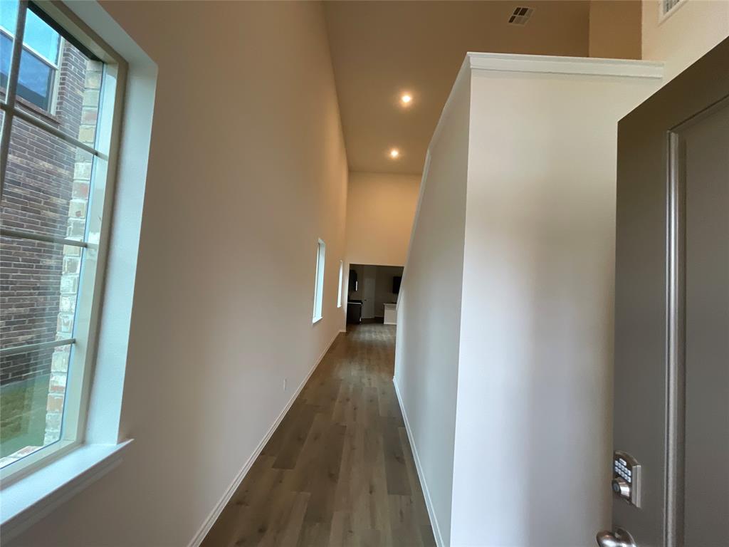 657 Chipper Trail Lavon, TX 75166 - Photo 4 of 24 a view of a hallway with wooden floor and staircase