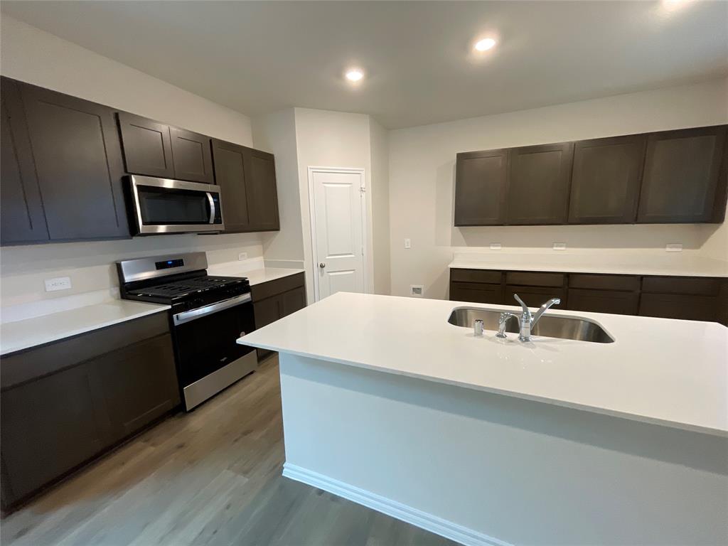 657 Chipper Trail Lavon, TX 75166 - Photo 9 of 24 a kitchen with a sink and stainless steel appliances