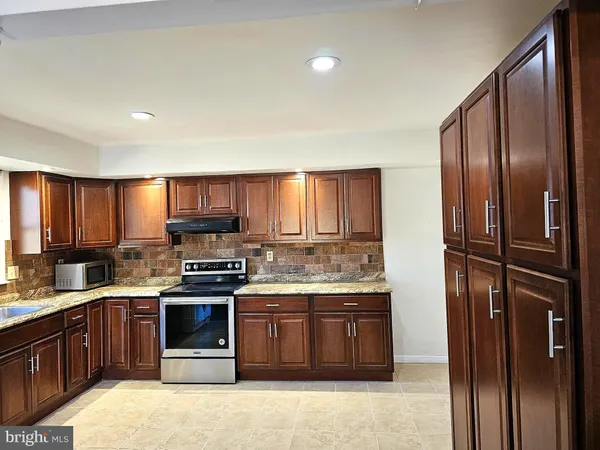 a kitchen with stainless steel appliances granite countertop a stove a refrigerator and a sink