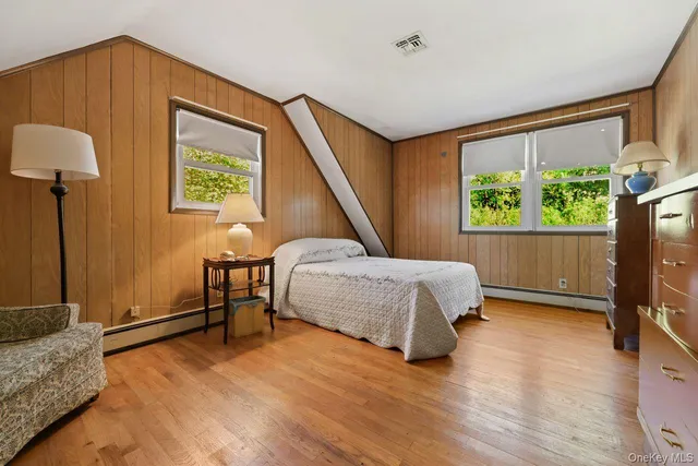 a bedroom with a bed and a dresser next to a window