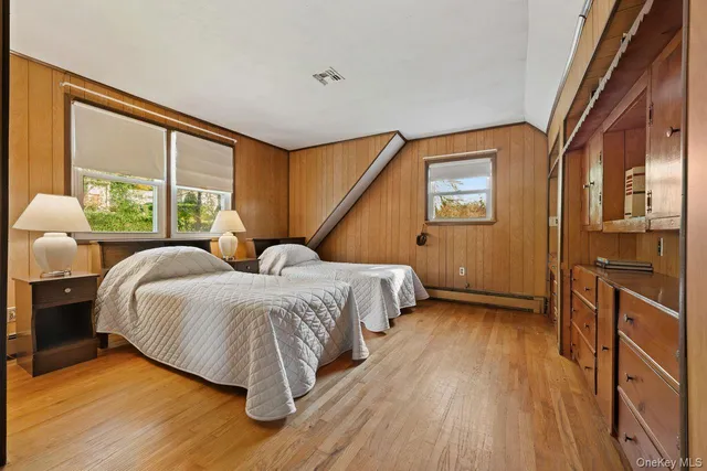 a spacious bedroom with a bed and wooden floor