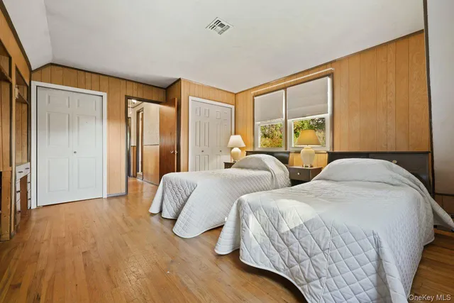 a bedroom with two beds and a large window