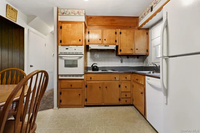 a kitchen with stainless steel appliances granite countertop a stove a sink and a refrigerator with wooden floor