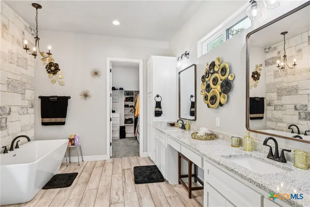 a spacious bathroom with a granite countertop sink a mirror a bathtub and shower