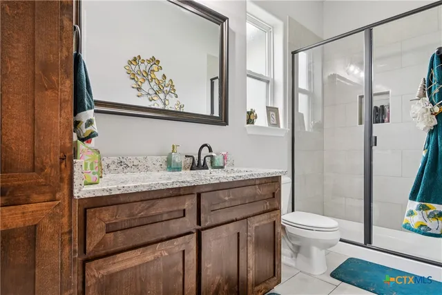 a bathroom with a granite countertop sink a toilet and a shower