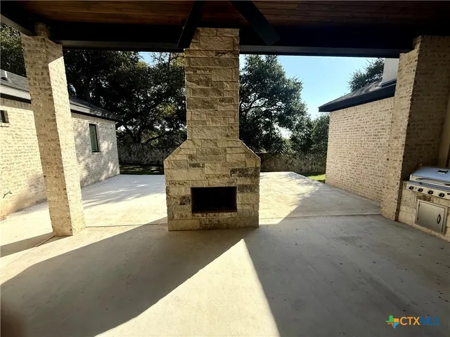 a view of an empty room with a fireplace and a tree