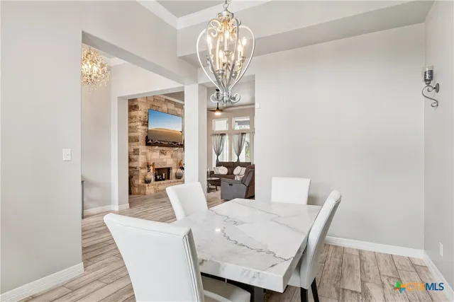 a view of a dining room with furniture and chandelier