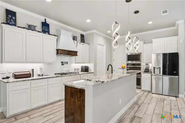a kitchen with a sink stainless steel appliances and cabinets