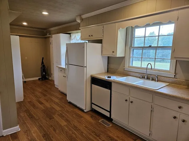 a kitchen with cabinets appliances a sink and a window