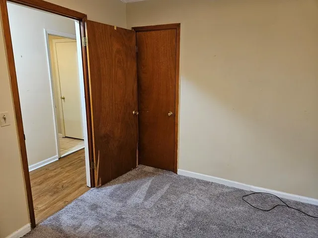 a view of empty room with window and wooden floor