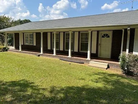 front view of a house with a large window and plants