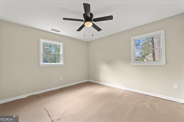 a view of empty room with ceiling fan
