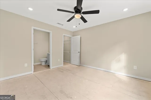 an empty room with ceiling fan and window