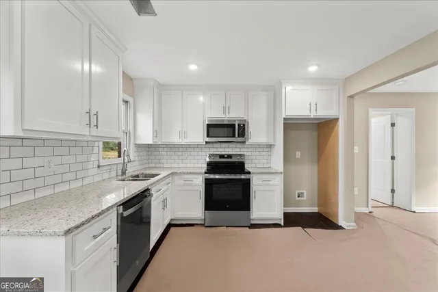 a kitchen with granite countertop a sink stainless steel appliances and cabinets