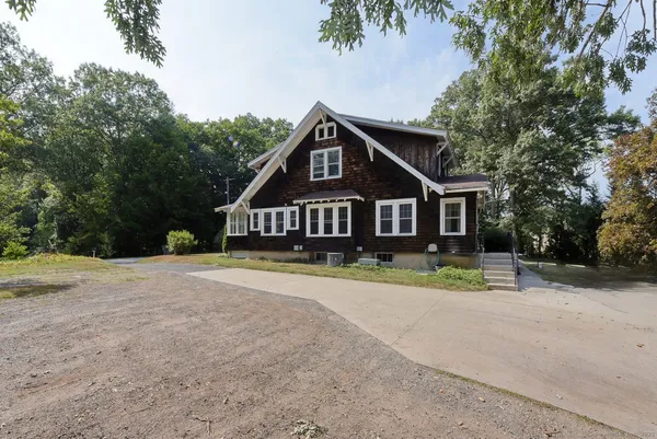 a front view of a house with a yard and trees