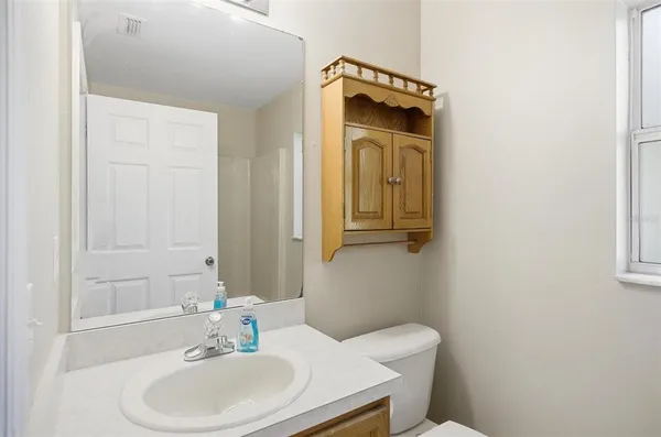 a bathroom with a sink toilet and mirror