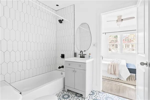 a bathroom with a sink a bathtub and a window