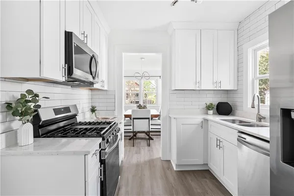 a kitchen with cabinets appliances a sink and a counter space