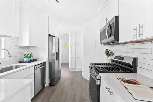 a kitchen with stainless steel appliances a stove a sink a refrigerator and cabinets