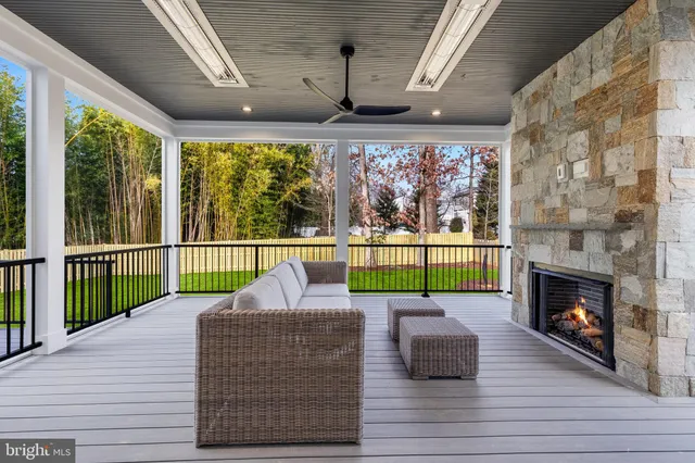 a living room with stainless steel appliances granite countertop furniture wooden floor and a fireplace