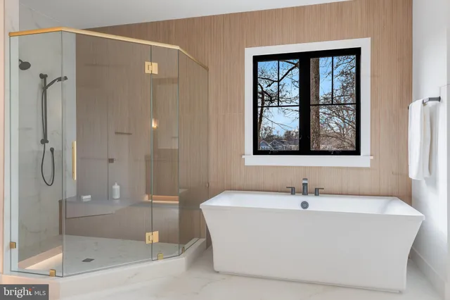 a spacious bathroom with a tub a sink and mirror