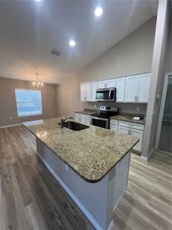 a kitchen with granite countertop a sink and a stove top oven