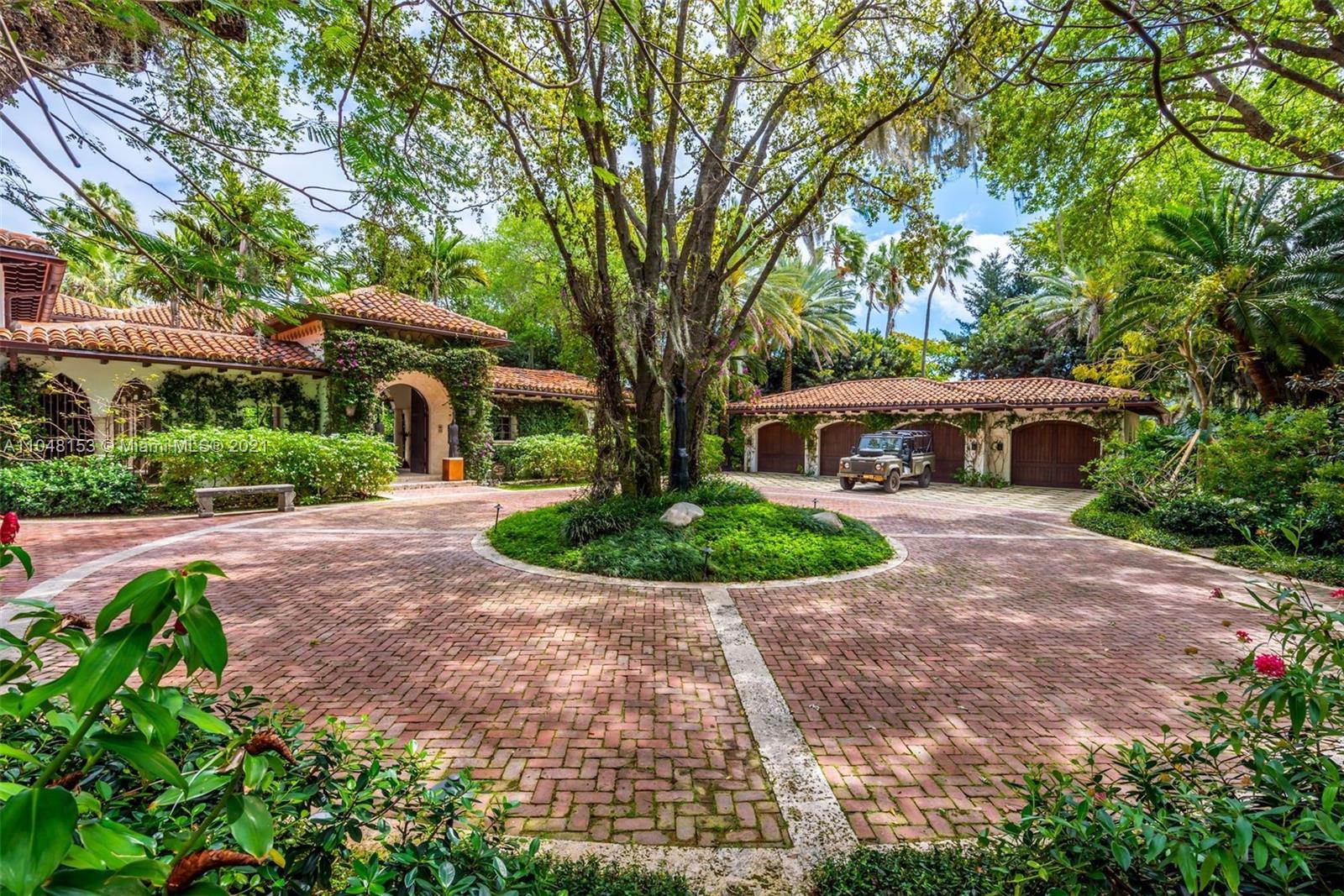 a front view of a house with a yard and potted plants